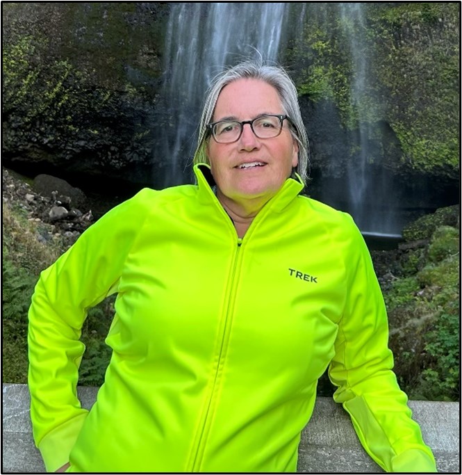 Woman in lime green shirt in front of waterfall